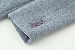 Detailed view of grey wool coat sleeve featuring classic three-button cuff design
