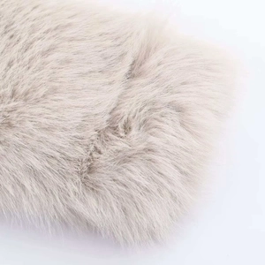 Gros plan sur la texture de fausse fourrure beige clair d'une veste d'hiver courte