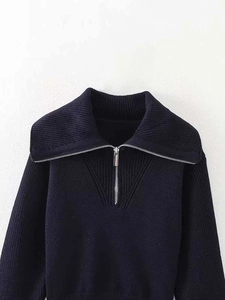 Gros plan détaillé d'un pull en maille bleu marine avec col zippé en métal argenté