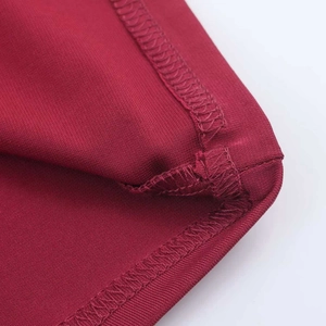 Detailed close-up of the neat hem stitching and texture on a burgundy summer maxi dress