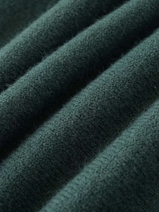 Close-up of soft dark green knitted fabric with a premium brushed texture and wool finish