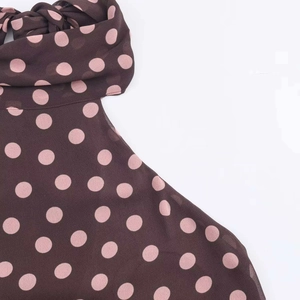 Detail of brown chiffon fabric with pink polka dots and halter neckline drapery