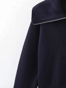 Détail de la fermeture éclair en métal et de la maille côtelée du pull bleu marine