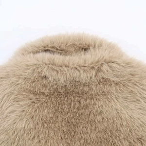 Close-up of soft tan faux fur texture on a winter jacket collar with plush fibers
