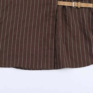 Détail du tissu à rayures marron foncé avec ceinture en cuir et boucle métallique