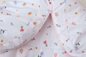Detailansicht der gesteppten Baby-Kapuzenjacke mit Blumenmuster und rosa Reißverschluss