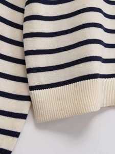 Detailed close-up of navy and cream striped knit fabric with ribbed hem texture