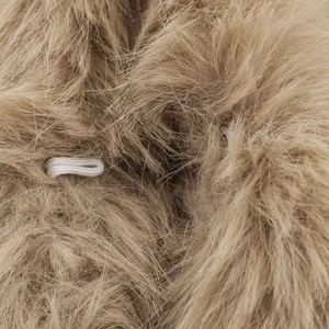 Close-up of soft camel faux fur texture with white elastic loop detail on the garment