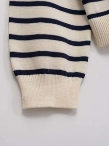 Detailed close-up of ribbed cuffs on a high-quality navy blue striped knit cardigan