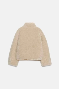 Détail de la texture polaire crème moelleuse à l'arrière de la veste réversible