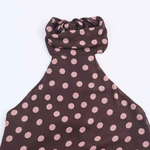 Close-up of halter neck tie on brown and pink polka dot top in lightweight fabric