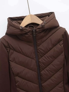 Close-up of quilted hooded puffer jacket in dark brown with metal zipper and drawstrings