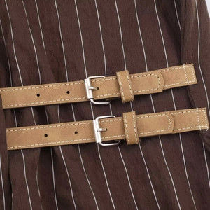 Chemise ample à rayures brunes avec détails de lanières décoratives et boucles argentées