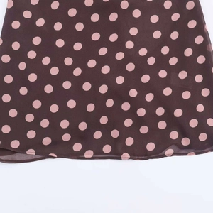 Detailed view of brown chiffon fabric with pink polka dot pattern and rolled hem edges