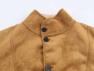 Détail d'une veste en daim marron avec doublure en laine d'agneau et fermeture à boutons