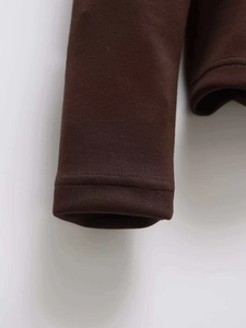 Detail shot of the double-needle stitching on the brown quilted jacket sleeve cuff