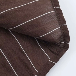 Gros plan détaillé du tissu marron à fines rayures montrant la texture et la couture