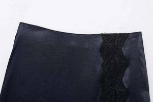 Détail de satin bleu marine lisse avec bordure en dentelle noire délicate sur la fente