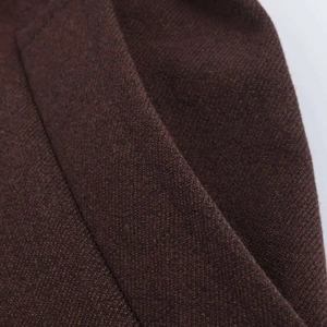 Detailed macro view of the dark brown high-density knitted fabric texture and fine stitching