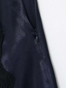 Vue détaillée de la fermeture éclair invisible et dentelle noire sur jupe en satin