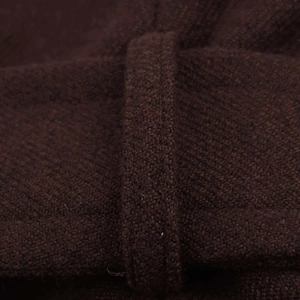 Detailed macro view of dark brown wool fabric texture and reinforced belt loop on coat