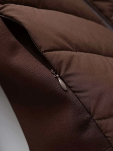 Detail of dark brown quilted puffer jacket featuring a discrete side zipper pocket