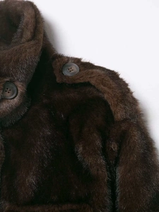 Close-up of deep brown faux fur coat showing shoulder epaulets with button details