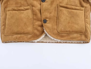 Détail de veste en daim marron avec doublure en peau de mouton et grandes poches