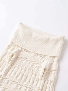 Detailed macro view of the cream turtleneck knit sweater featuring hollow-out floral patterns