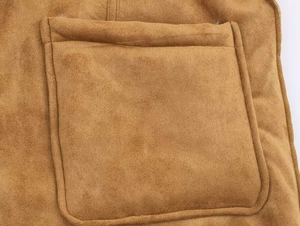 Détail de la poche plaquée carrée sur une veste d'hiver en daim réversible marron