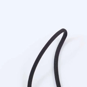 Détail macro de fines bretelles en satin noir avec coutures précises et éclat subtil