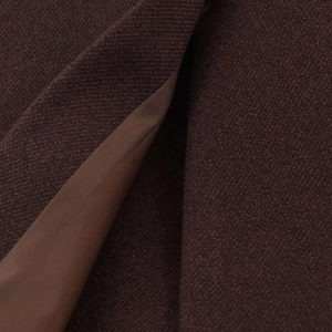 Detail of dark brown wool coat showing thick woven texture and smooth silk lining