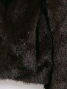 Close-up of premium dark brown faux fur texture showing soft dense fibers and natural gloss