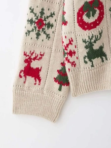 Nahaufnahme der Stricktextur mit Rentier- und Schneeflockenmuster auf Winterpullover