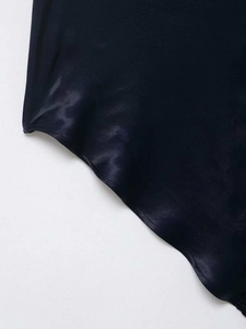 Détail de la texture satinée bleu marine avec fini lisse et ourlet ondulé discret