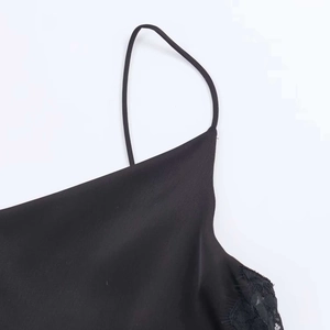 Vue macro détaillée du tissu en satin noir avec bordure en dentelle cil et fine bretelle
