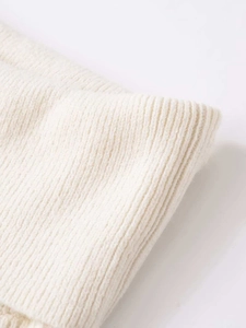 Close-up of off-white ribbed knit texture showing soft, breathable fabric detail