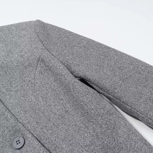 Close-up of grey wool blend coat featuring stitching details and matching button
