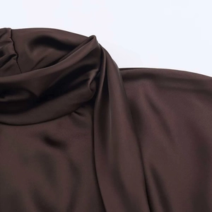 Macro detail of dark coffee satin dress featuring soft pleated neck and silky texture