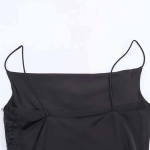 Détail du caraco en satin noir avec bordure en dentelle fine et fines bretelles