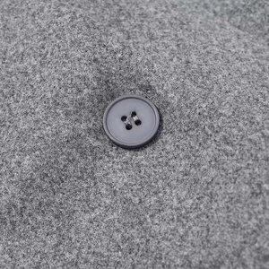 Macro shot of grey wool blend fabric texture and a grey four-hole button detail