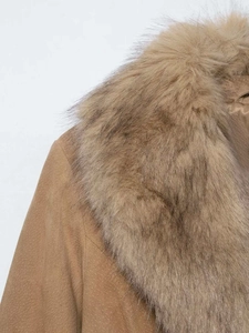 Détail macro d'une veste en daim camel avec un large col en fausse fourrure douce