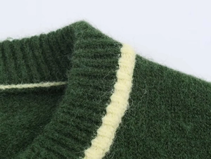 Detailed view of dark green knit sweater collar with contrasting cream-colored striped trim