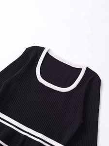 Detail of square neckline with white contrast trim on a black ribbed knit top