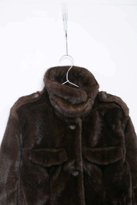 Detail shot of deep brown faux fur jacket with high collar and large front pockets