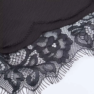 Gros plan détaillé du satin noir avec bordure en dentelle florale délicate et raffinée