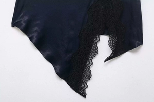 Détail de jupe en satin noir avec bordure en dentelle florale et fente latérale chic