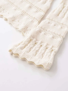 Detailed macro view of white pointelle knit sleeve with delicate scalloped edges