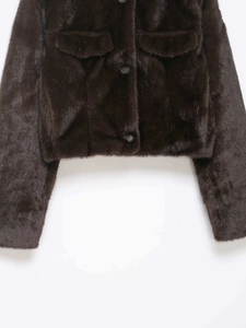 Detailed texture of dark brown faux fur jacket with flap pockets and round buttons