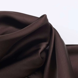 Macro detail of dark brown satin fabric with smooth texture and luxury glossy finish